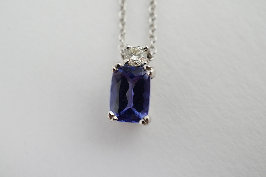 A modern 18ct white gold, tanzanite and diamond set pendant, 10mm, on an 18ct white gold chain, 39cm, gross weight 3.1 grams. Condition - good